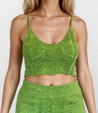 Woman wearing knit crop tank top. White//grey background.