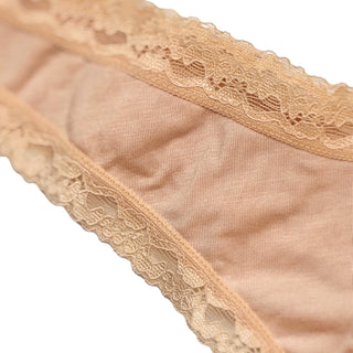 Close up view of beige lace-trimmed fabric on a white background